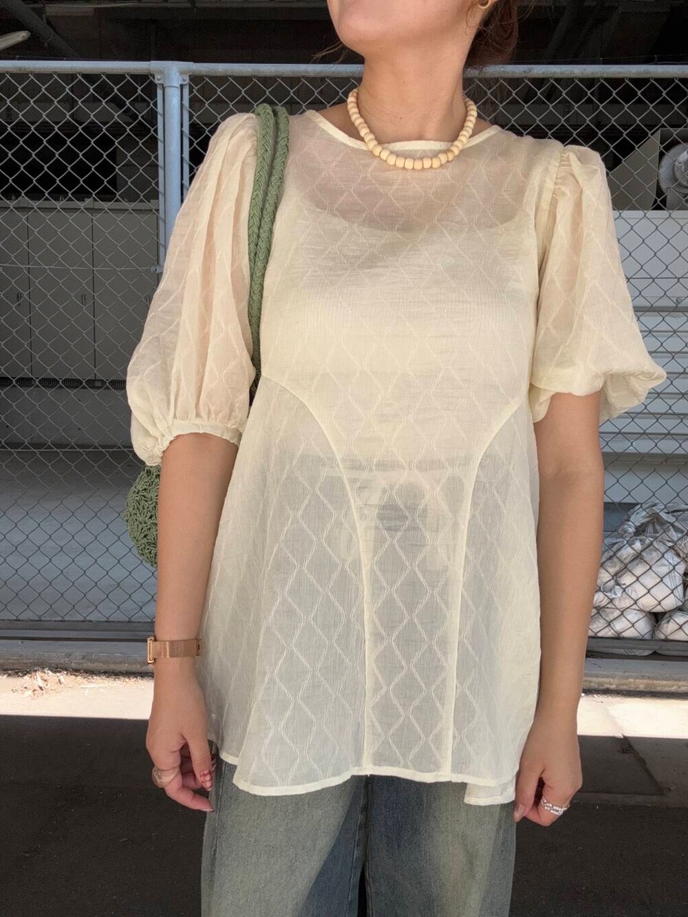 ブルー系のデニムパンツ、グリーン系のトートバッグ、ホワイト系のシャツ/ブラウスを着用したレディースの夏コーディネートの4枚目の写真