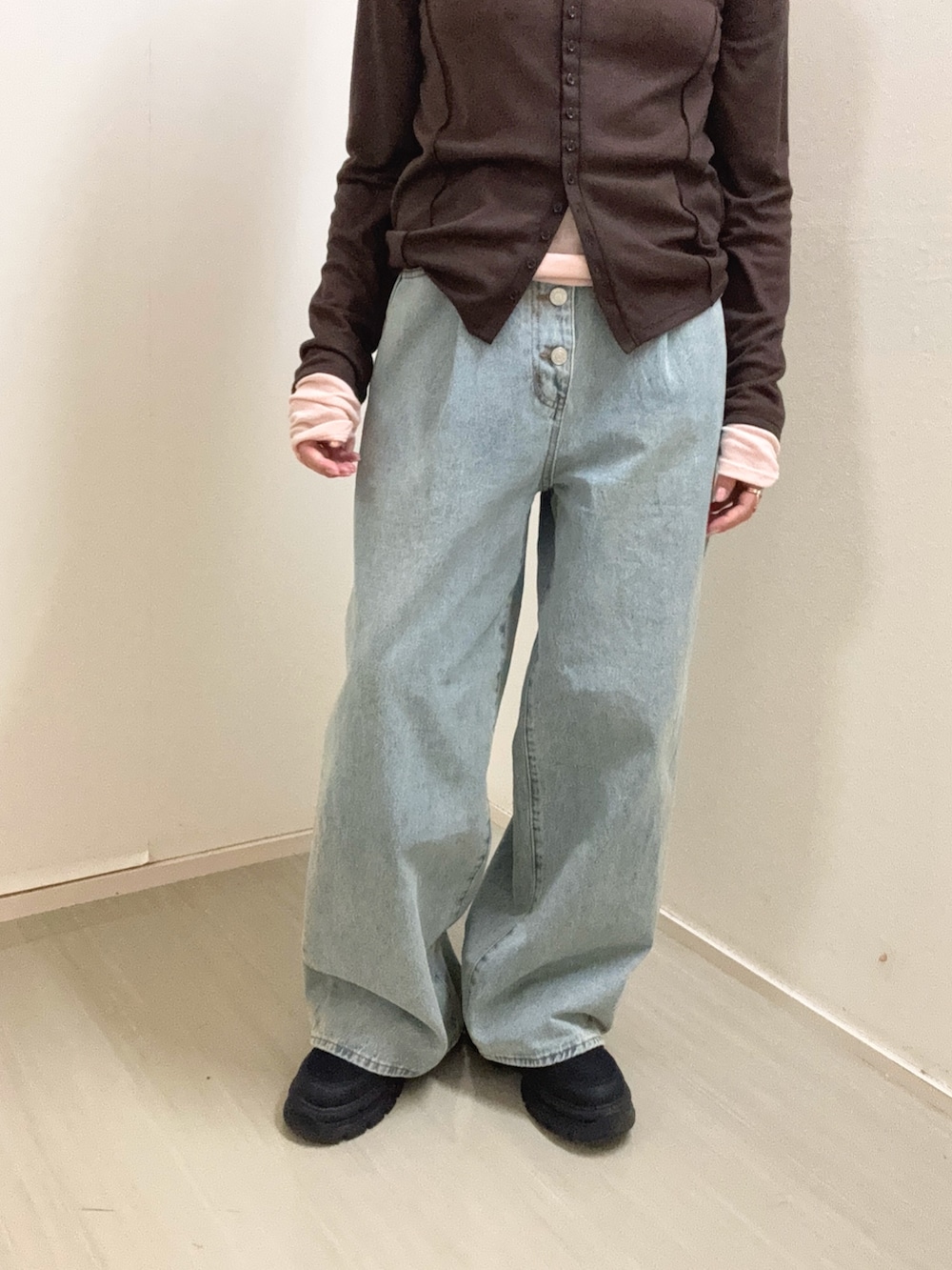 ブルー系のデニムパンツ、ブラウン系のTシャツ/カットソー、ブラック系のスニーカーを着用したレディースの冬コーディネートの5枚目の写真