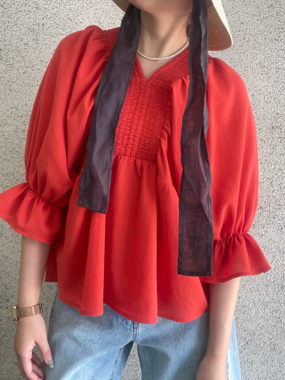 レッド系のシャツ/ブラウス、ブルー系のデニムパンツ、ホワイト系のハットを着用したレディースの春コーディネートの5枚目の写真