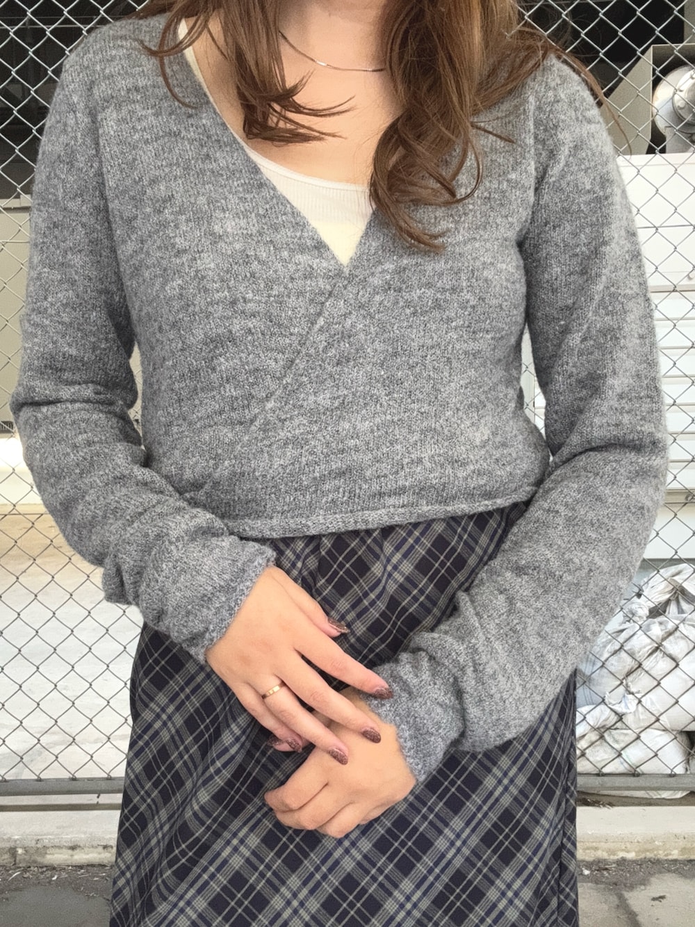 グレー系のニット/セーター、ブルー系のスカート、ブラック系のハンチング/ベレー帽を着用したレディースの秋コーディネートの4枚目の写真
