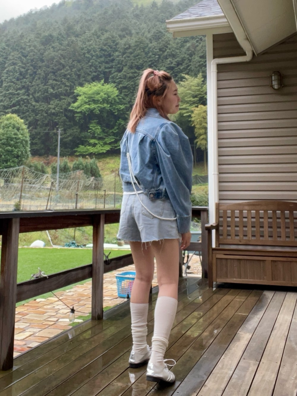 ブルー系のデニムジャケット、シルバー系のネックレスを着用したレディースの春コーディネートの4枚目の写真