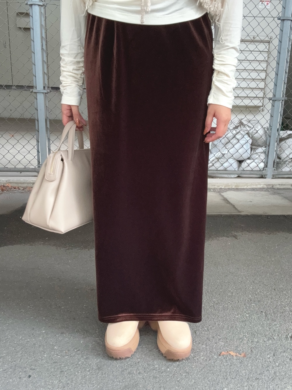 ブラウン系のスカート、ベージュ系のベスト、ホワイト系のTシャツ/カットソーを着用したレディースの秋コーディネートの5枚目の写真