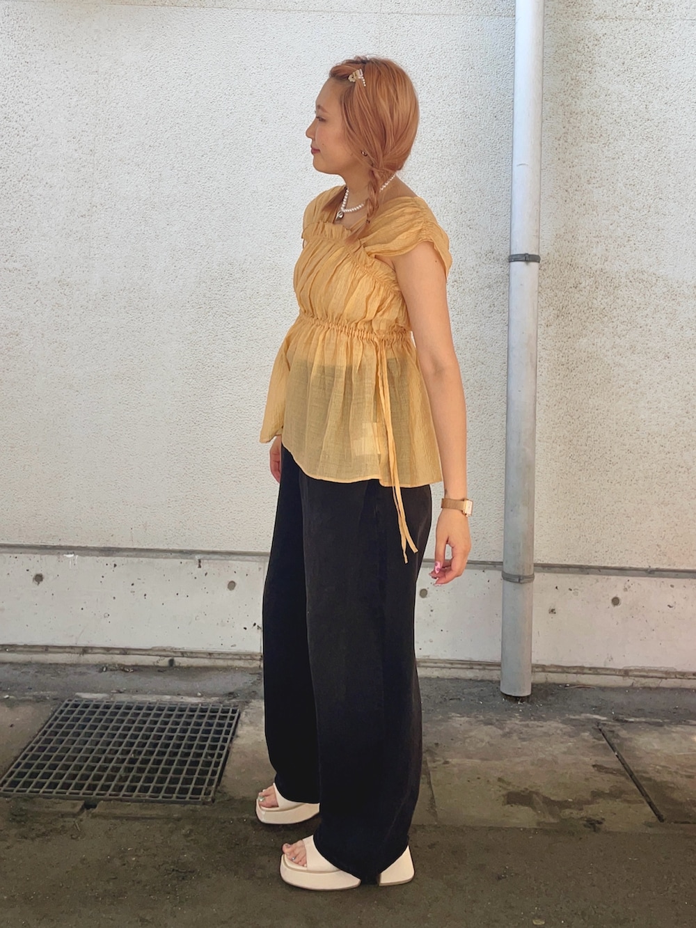 オレンジ系のシャツ/ブラウス、ブラック系のデニムパンツを着用したレディースの夏コーディネートの2枚目の写真