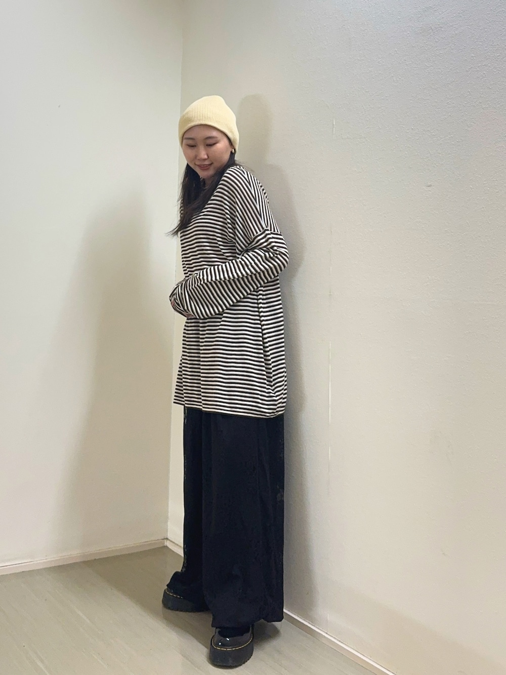 ブラウン系のニット/セーター、ブラック系のその他パンツ、ホワイト系のニットキャップ/ビーニーを着用したレディースの春コーディネートの2枚目の写真