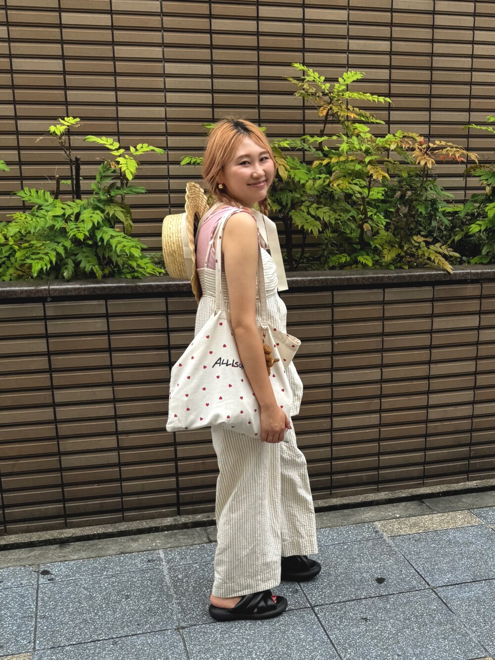 レッド系のシャツ/ブラウス、レッド系のその他パンツ、ホワイト系のハットを着用したレディースの夏コーディネートの2枚目の写真