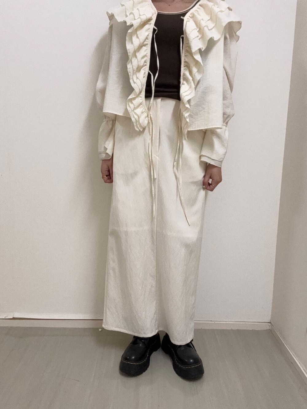 ホワイト系のシャツ/ブラウス、ブラウン系のタンクトップ、ホワイト系のスカートを着用したレディースの春コーディネートの6枚目の写真