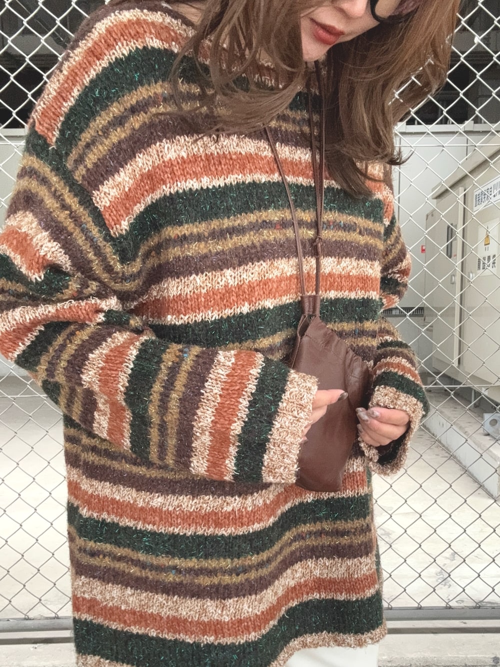 ブラウン系のニット/セーター、ホワイト系のその他パンツ、ブラウン系のローファーを着用したレディースの秋コーディネートの4枚目の写真