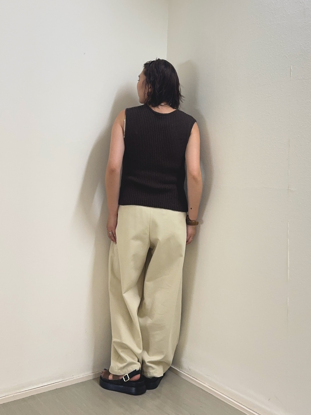 ベージュ系のその他パンツ、ブラウン系のベスト、ブラック系のサンダルを着用したレディースの夏コーディネートの2枚目の写真