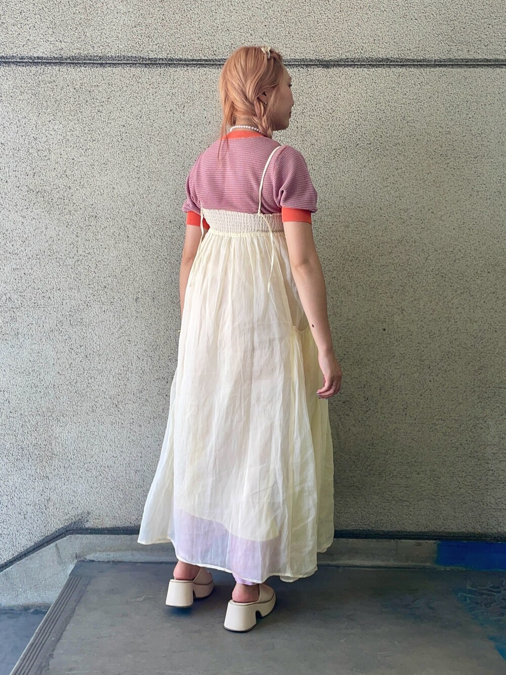 ホワイト系のワンピース、オレンジ系のニット/セーターを着用したレディースの夏コーディネートの2枚目の写真