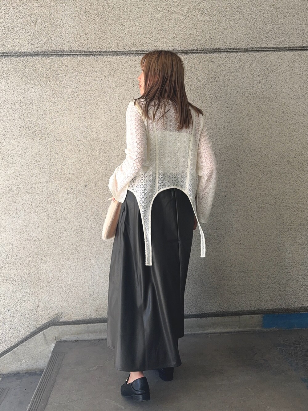 ブラウン系のスカート、ホワイト系のTシャツ/カットソー、ホワイト系のショルダーバッグを着用したレディースの秋コーディネートの4枚目の写真