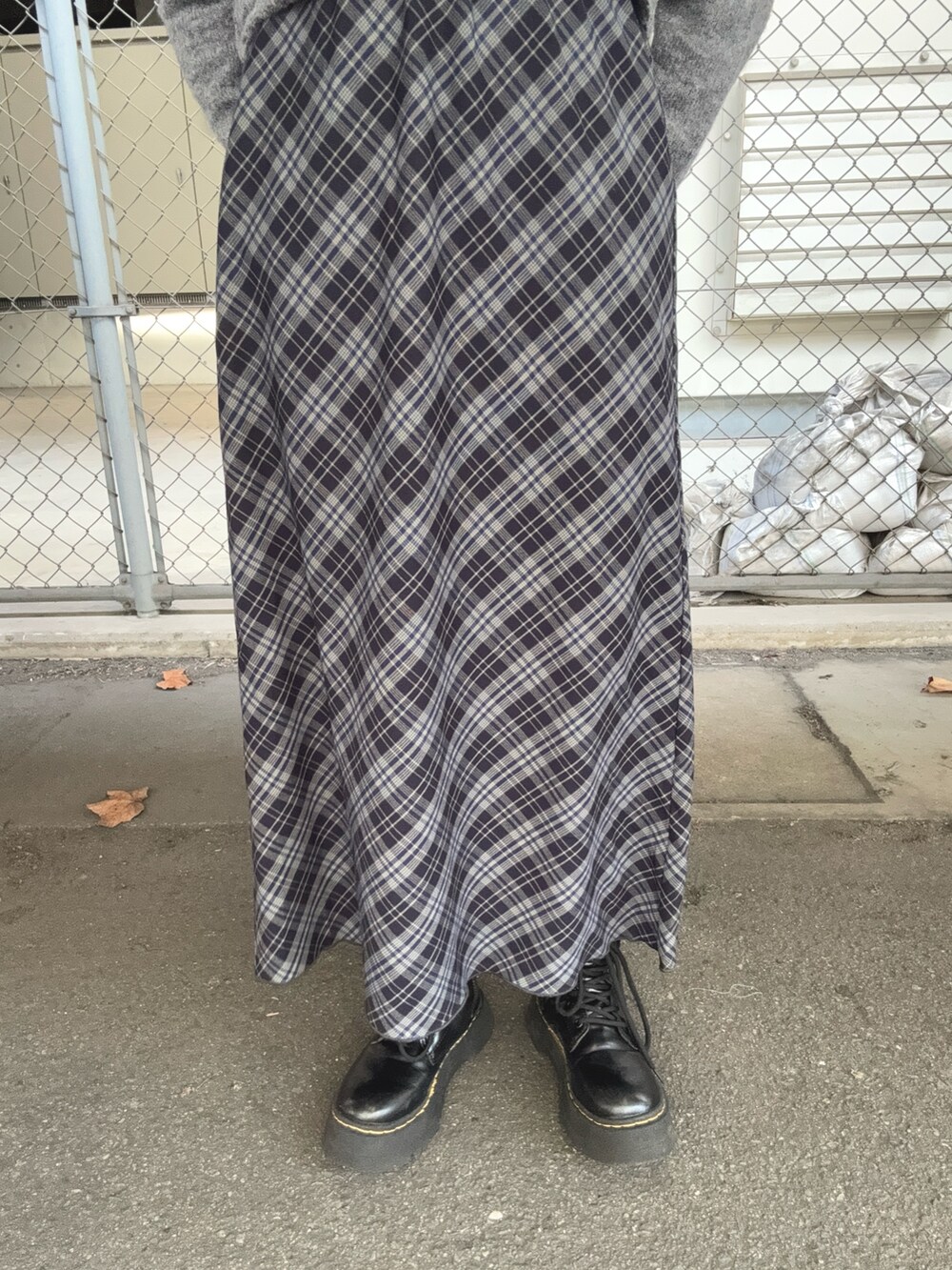 グレー系のニット/セーター、ブルー系のスカート、ブラック系のハンチング/ベレー帽を着用したレディースの秋コーディネートの5枚目の写真