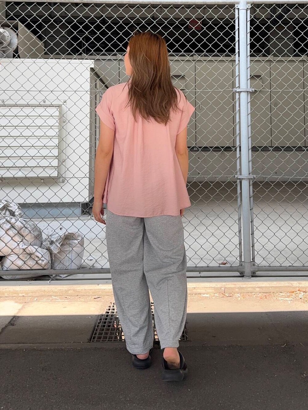 グレー系のその他パンツ、ピンク系のシャツ/ブラウスを着用したレディースの夏コーディネートの3枚目の写真