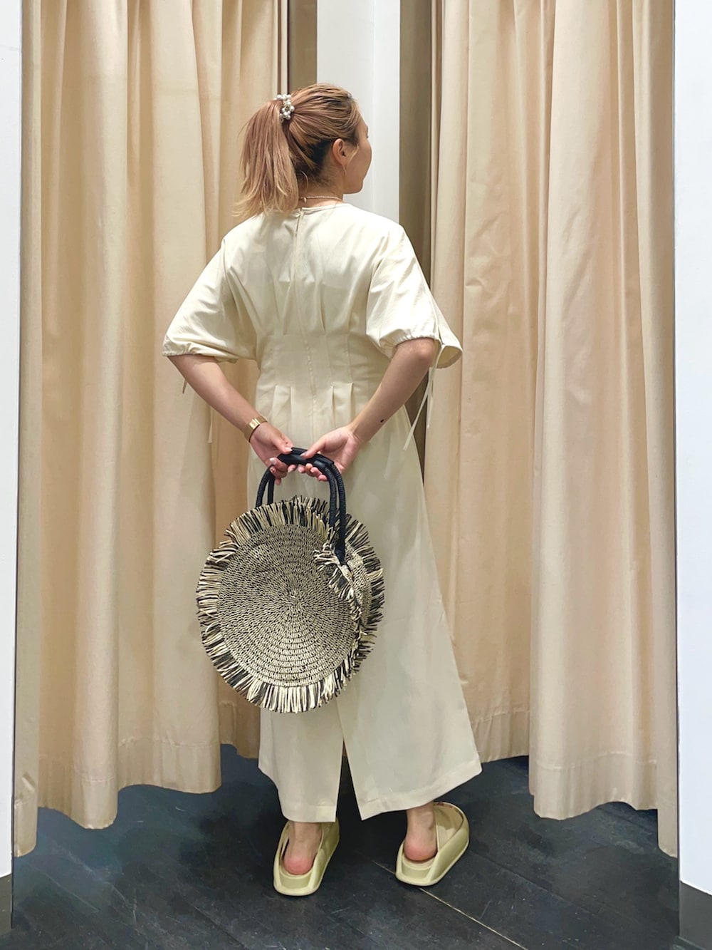 ホワイト系のワンピース、イエロー系のサンダル、ブラック系のハンドバッグを着用したレディースの春コーディネートの4枚目の写真