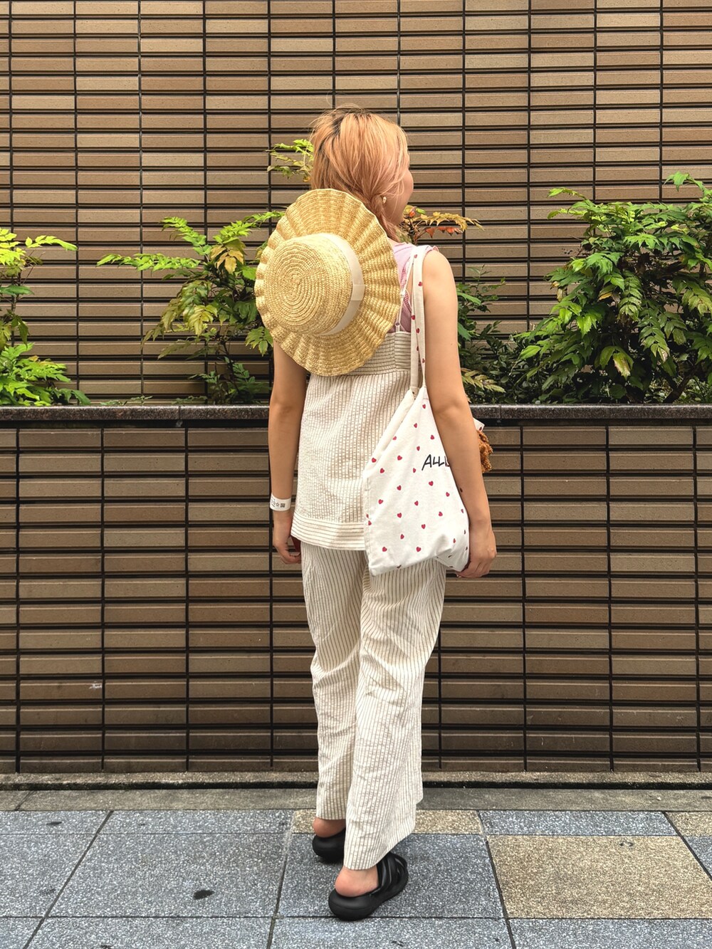レッド系のシャツ/ブラウス、レッド系のその他パンツ、ホワイト系のハットを着用したレディースの夏コーディネートの3枚目の写真