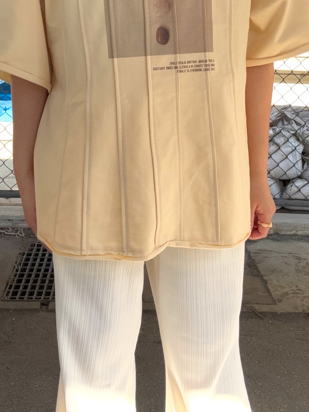 ホワイト系のその他パンツ、イエロー系のTシャツ/カットソー、ブラック系のスニーカーを着用したレディースの春コーディネートの5枚目の写真