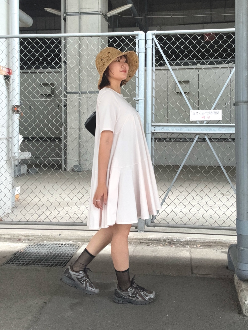 ピンク系のワンピース、ブラック系のその他パンツ、ブラック系のトートバッグを着用したレディースの夏コーディネートの2枚目の写真