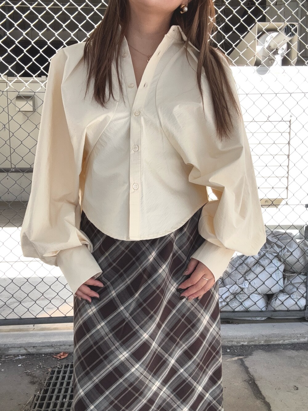 ブラウン系のスカート、ベージュ系のシャツ/ブラウス、ブラック系のスニーカーを着用したレディースの秋コーディネートの5枚目の写真