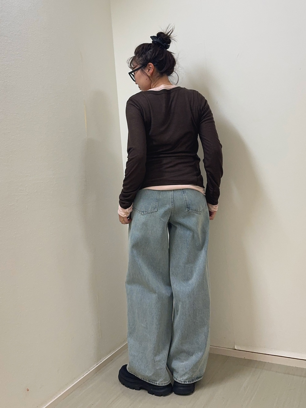 ブルー系のデニムパンツ、ブラウン系のTシャツ/カットソー、ブラック系のスニーカーを着用したレディースの冬コーディネートの3枚目の写真