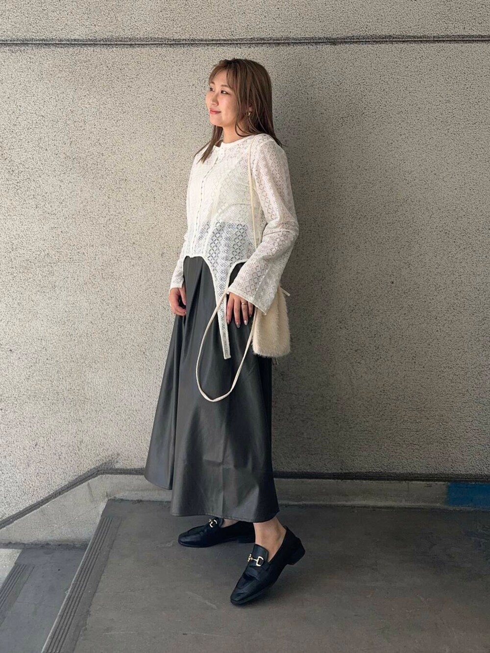 ホワイト系のショルダーバッグ、ホワイト系のTシャツ/カットソー、ブラウン系のスカートを着用したレディースの秋コーディネートの2枚目の写真