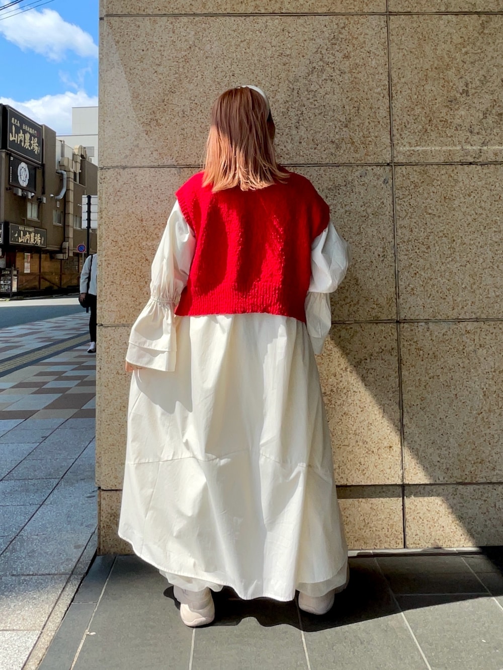 ホワイト系のワンピース、レッド系のニット/セーター、イエロー系のショルダーバッグを着用したレディースの春コーディネートの3枚目の写真