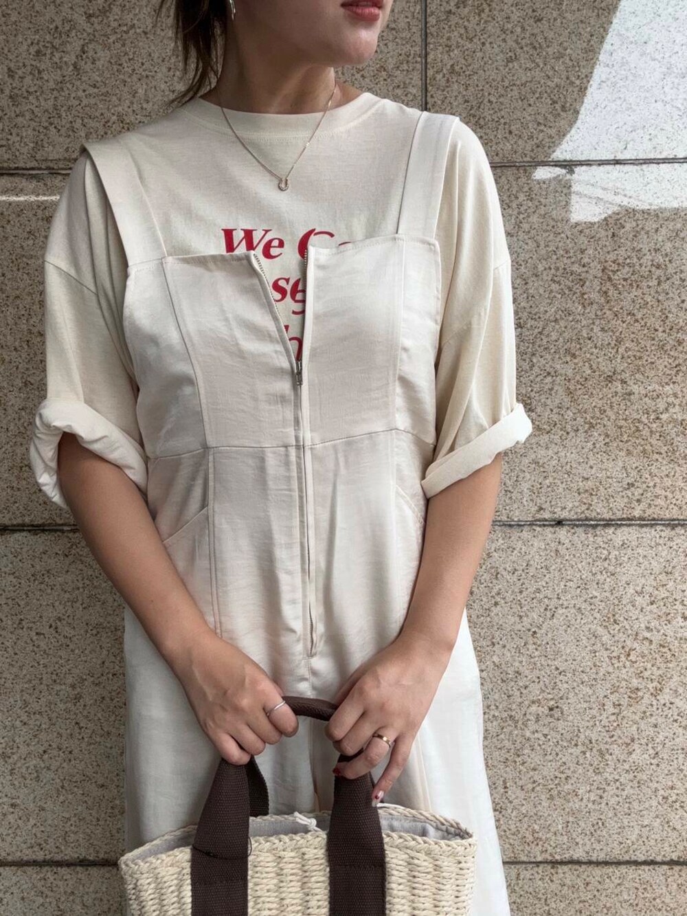 ホワイト系のハンドバッグ、ホワイト系のサロペット/オーバーオール、イエロー系のTシャツ/カットソーを着用したレディースの夏コーディネートの4枚目の写真