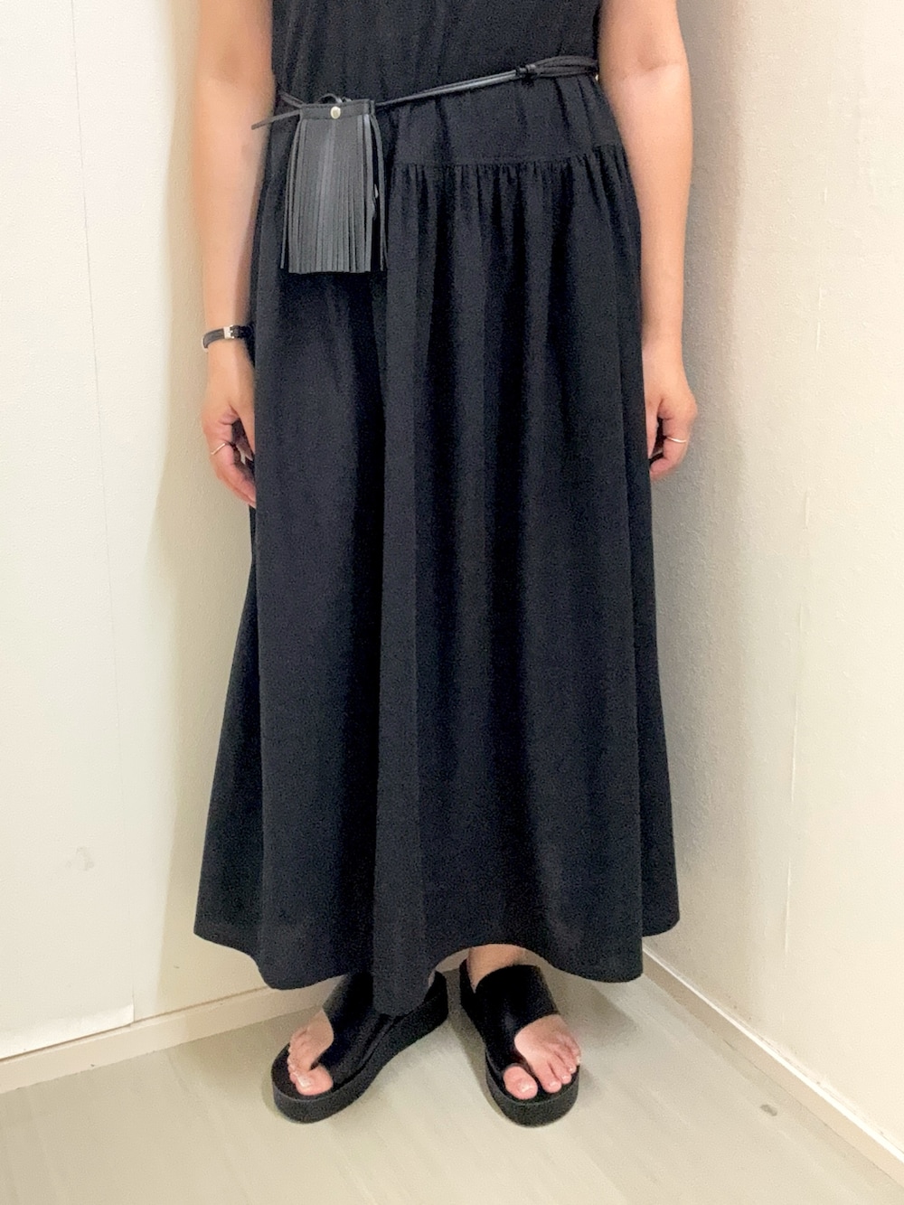 ブラック系のワンピース、ホワイト系のキャミソール、ブラック系のサンダルを着用したレディースの夏コーディネートの4枚目の写真