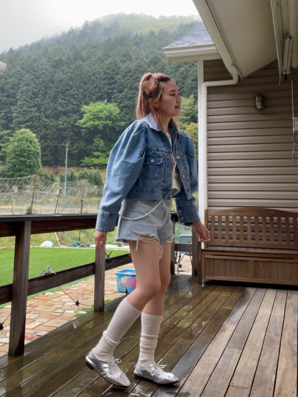 ブルー系のデニムジャケット、シルバー系のネックレスを着用したレディースの春コーディネートの5枚目の写真