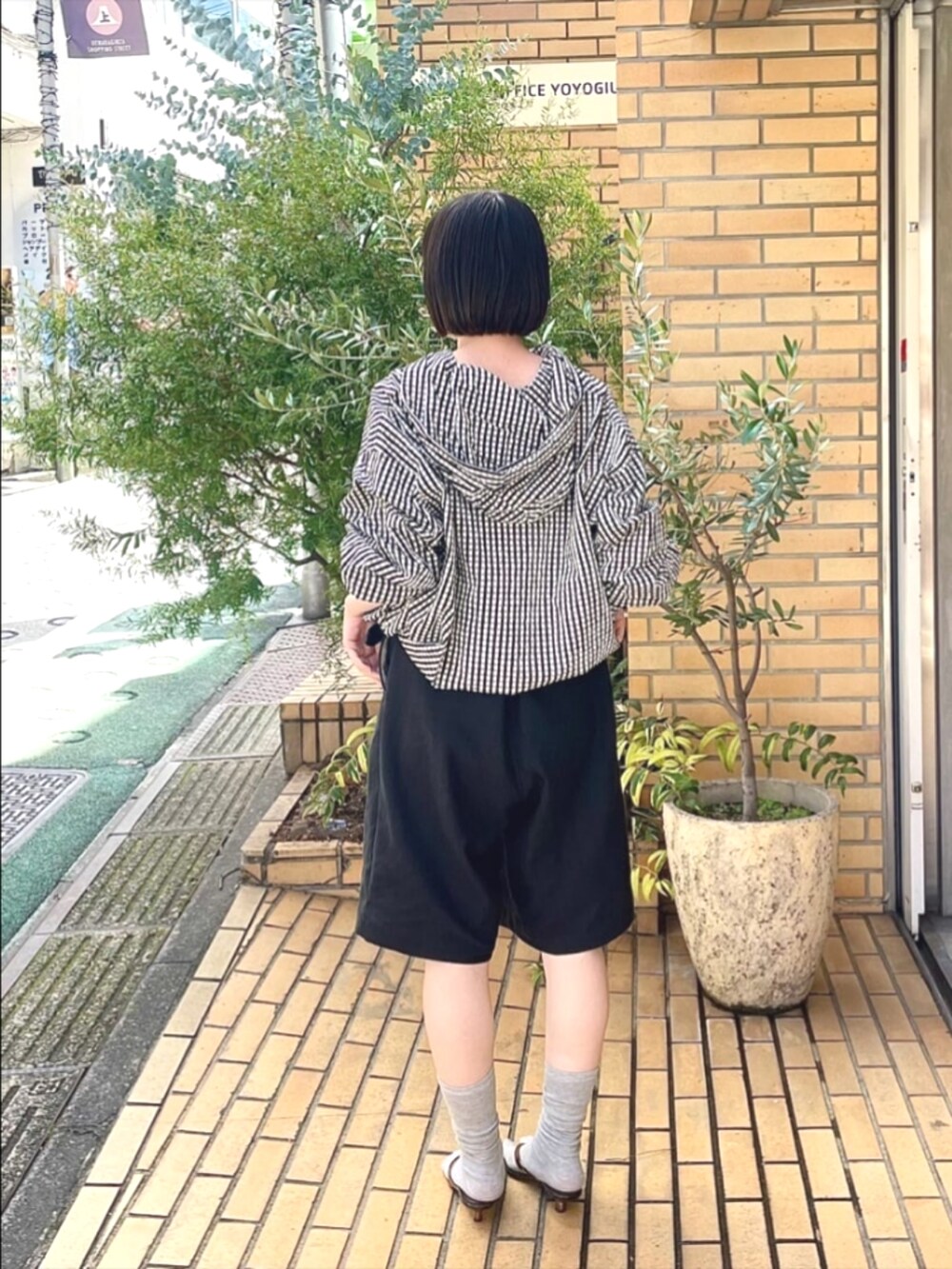 ブラック系のシャツ/ブラウスを着用したレディースの夏コーディネートの2枚目の写真