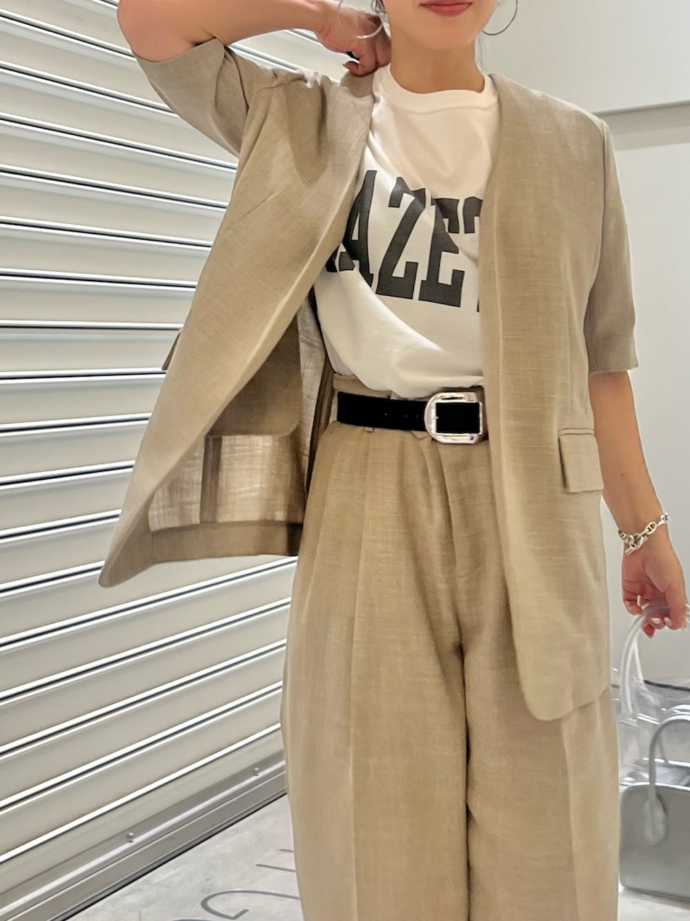 ベージュ系のノーカラージャケット、ベージュ系のスラックス、ホワイト系のTシャツ/カットソーを着用したレディースの夏コーディネートの3枚目の写真