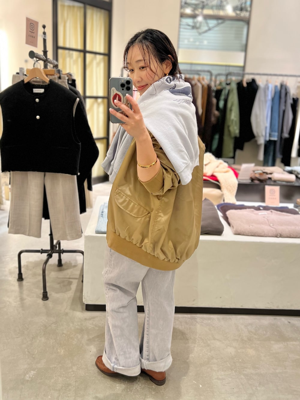 グレー系のデニムパンツ、ベージュ系のMA-1、ホワイト系のTシャツ/カットソーを着用したレディースの冬コーディネートの4枚目の写真