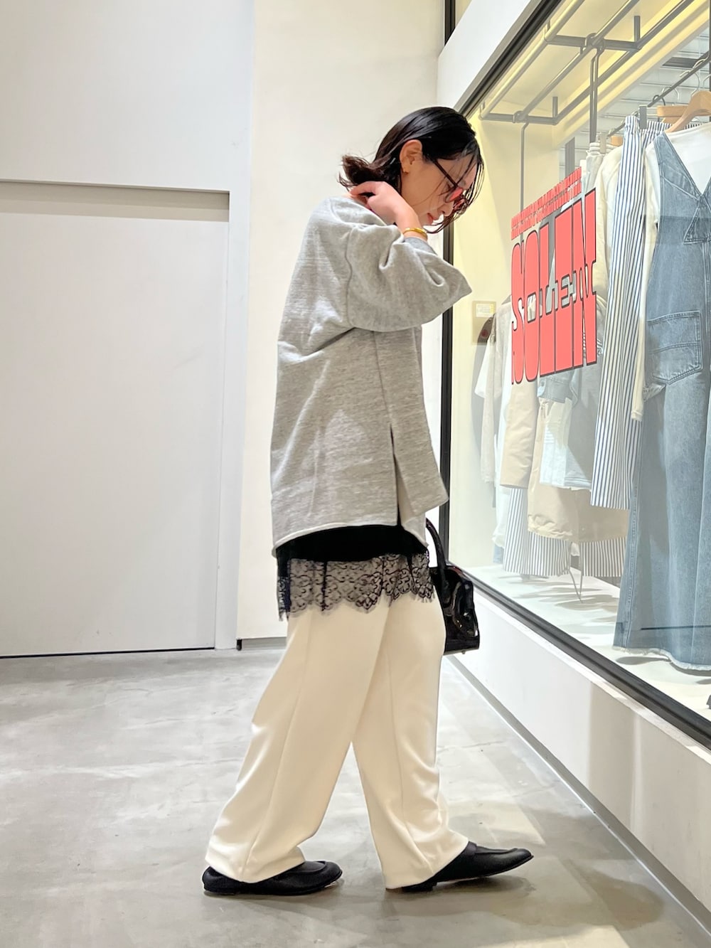 グレー系のスウェット、ホワイト系のその他パンツ、ブラック系のボストンバッグを着用したレディースの春コーディネートの5枚目の写真