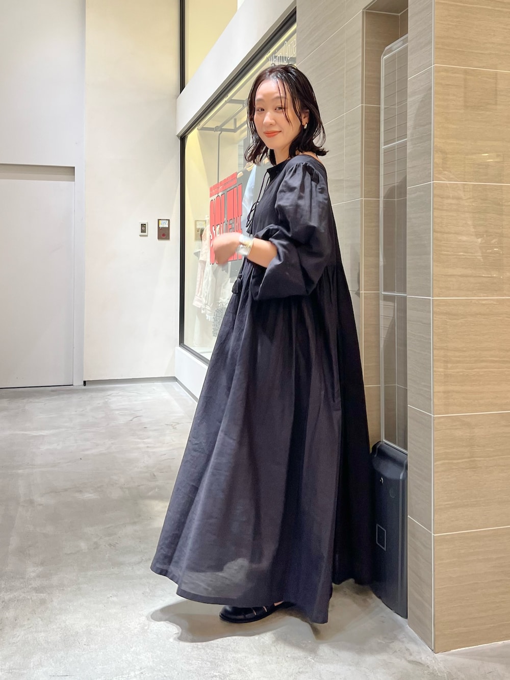 ブラック系のワンピース、ブラック系のサンダル、ブラック系のボストンバッグを着用したレディースの春コーディネートの3枚目の写真