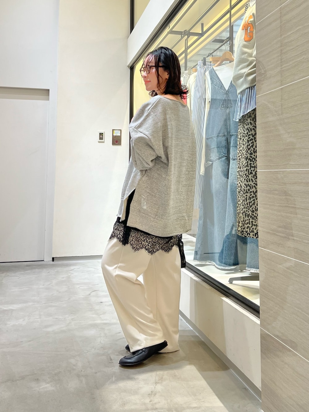 グレー系のスウェット、ホワイト系のその他パンツ、ブラック系のボストンバッグを着用したレディースの春コーディネートの2枚目の写真