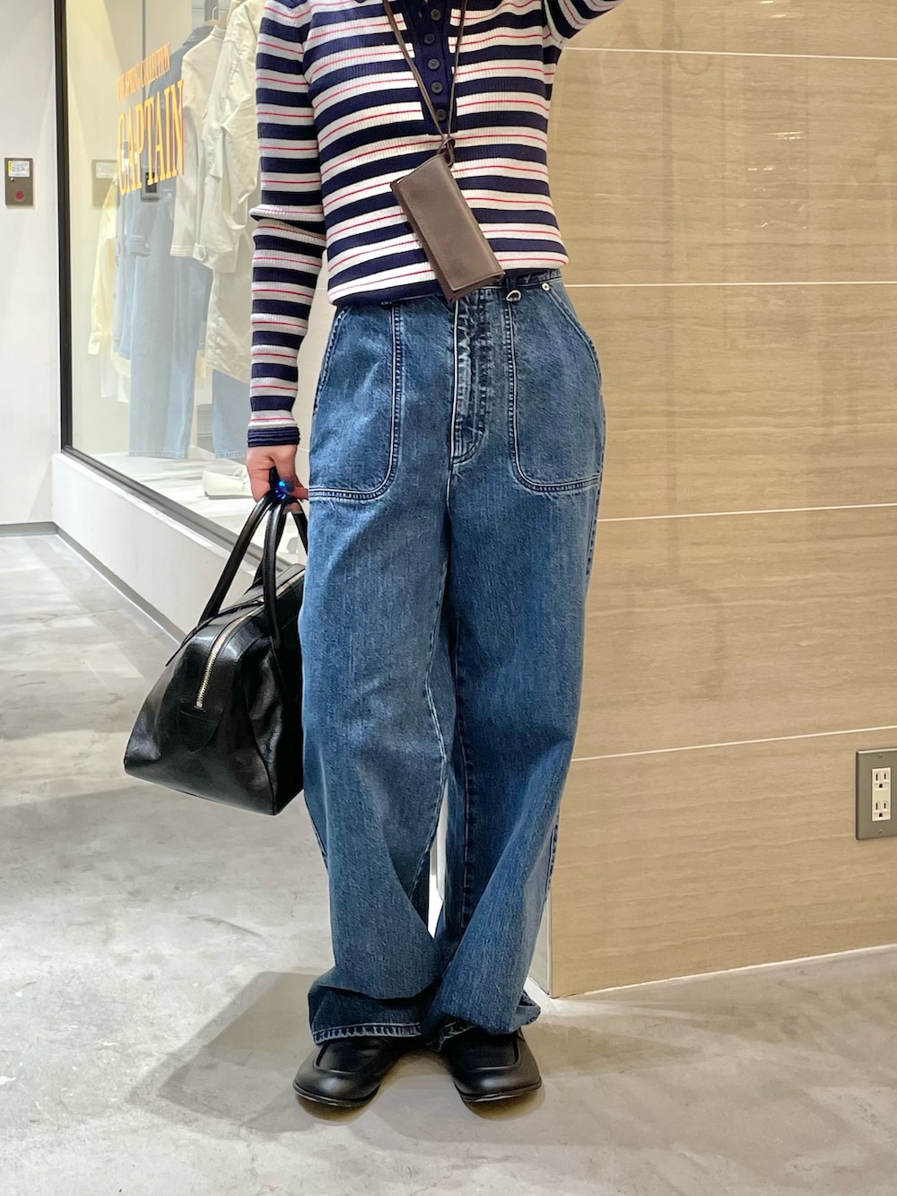 ブルー系のデニムパンツ、ブラック系のローファー、ブラック系のトートバッグを着用したレディースの冬コーディネートの5枚目の写真