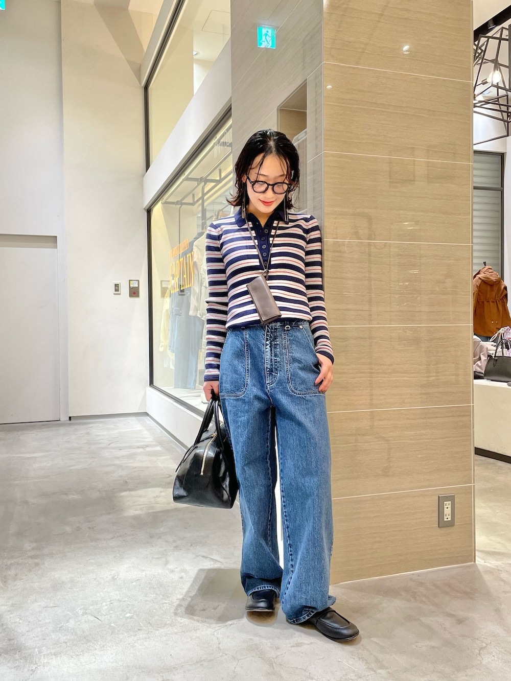 ブルー系のデニムパンツ、ブラック系のローファー、ブラック系のトートバッグを着用したレディースの冬コーディネートの4枚目の写真