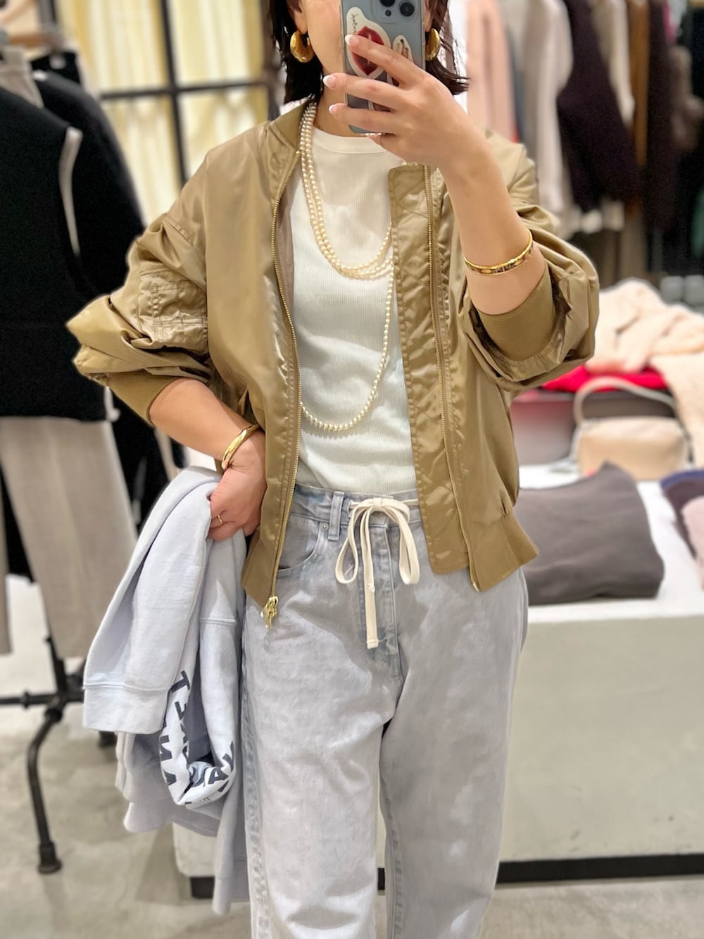 グレー系のデニムパンツ、ベージュ系のMA-1、ホワイト系のTシャツ/カットソーを着用したレディースの冬コーディネートの2枚目の写真