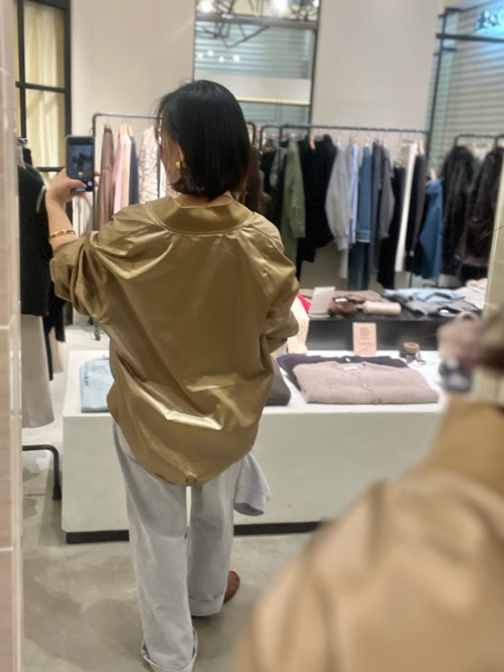 グレー系のデニムパンツ、ベージュ系のMA-1、ホワイト系のTシャツ/カットソーを着用したレディースの冬コーディネートの5枚目の写真