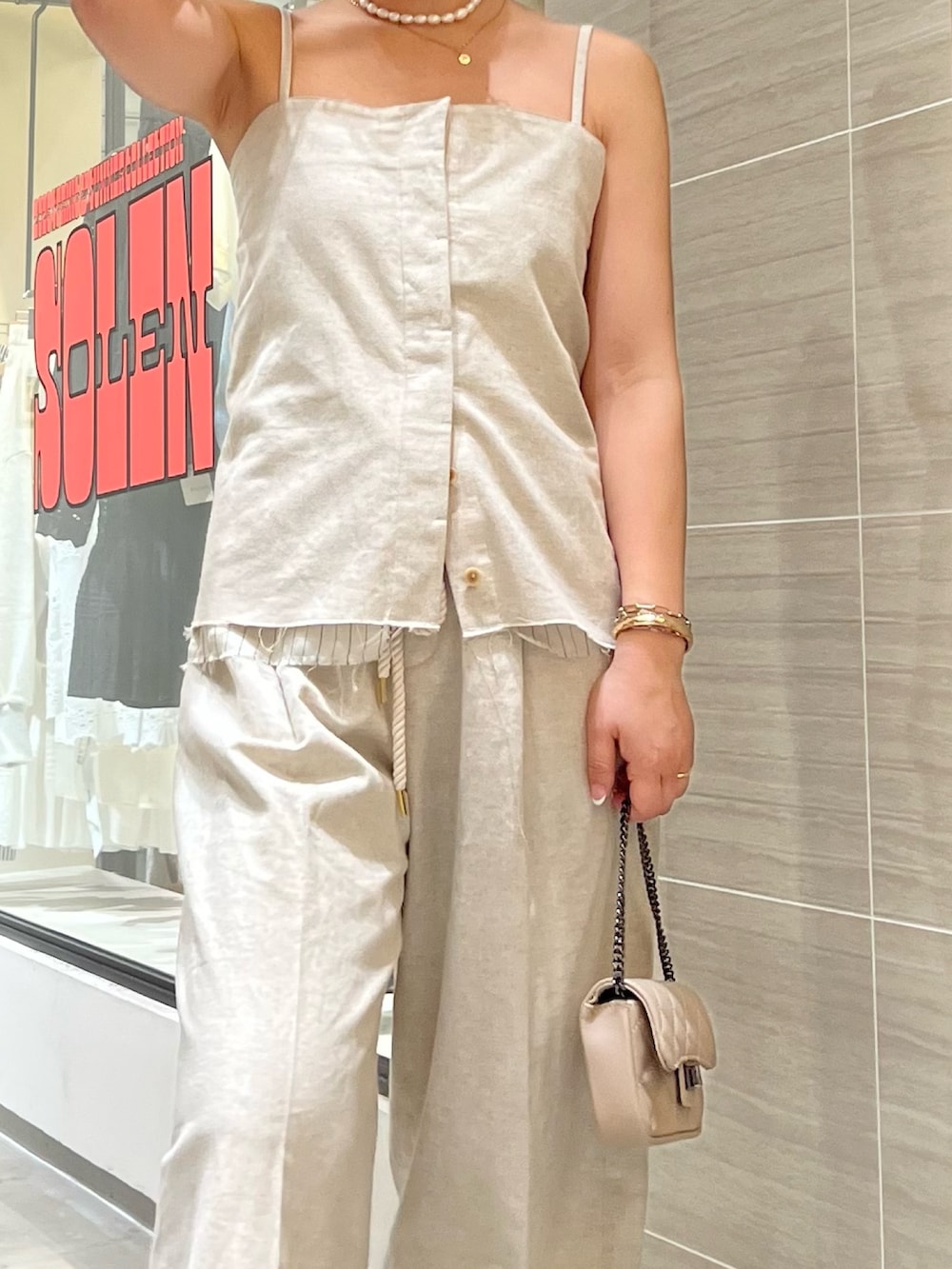 イエロー系のその他アウター、ベージュ系のその他パンツ、ベージュ系のショルダーバッグを着用したレディースの春コーディネートの6枚目の写真