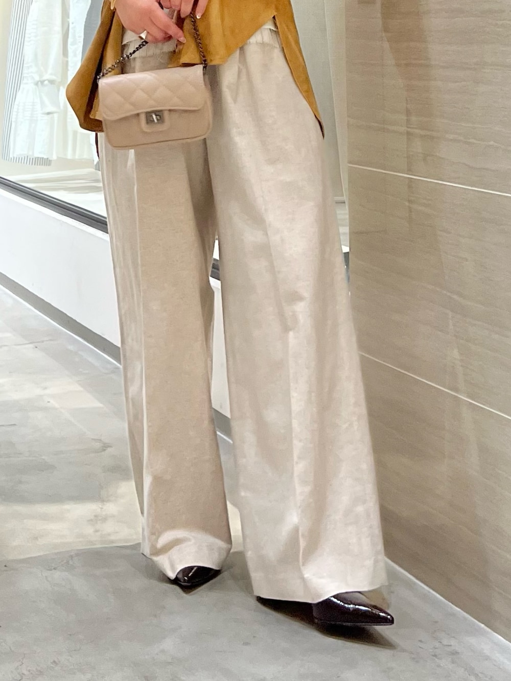 イエロー系のその他アウター、ベージュ系のその他パンツ、ベージュ系のショルダーバッグを着用したレディースの春コーディネートの7枚目の写真