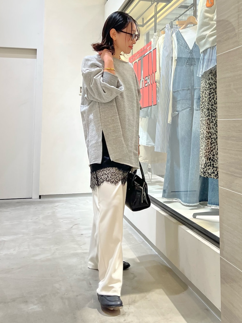 グレー系のスウェット、ホワイト系のその他パンツ、ブラック系のボストンバッグを着用したレディースの春コーディネートの6枚目の写真