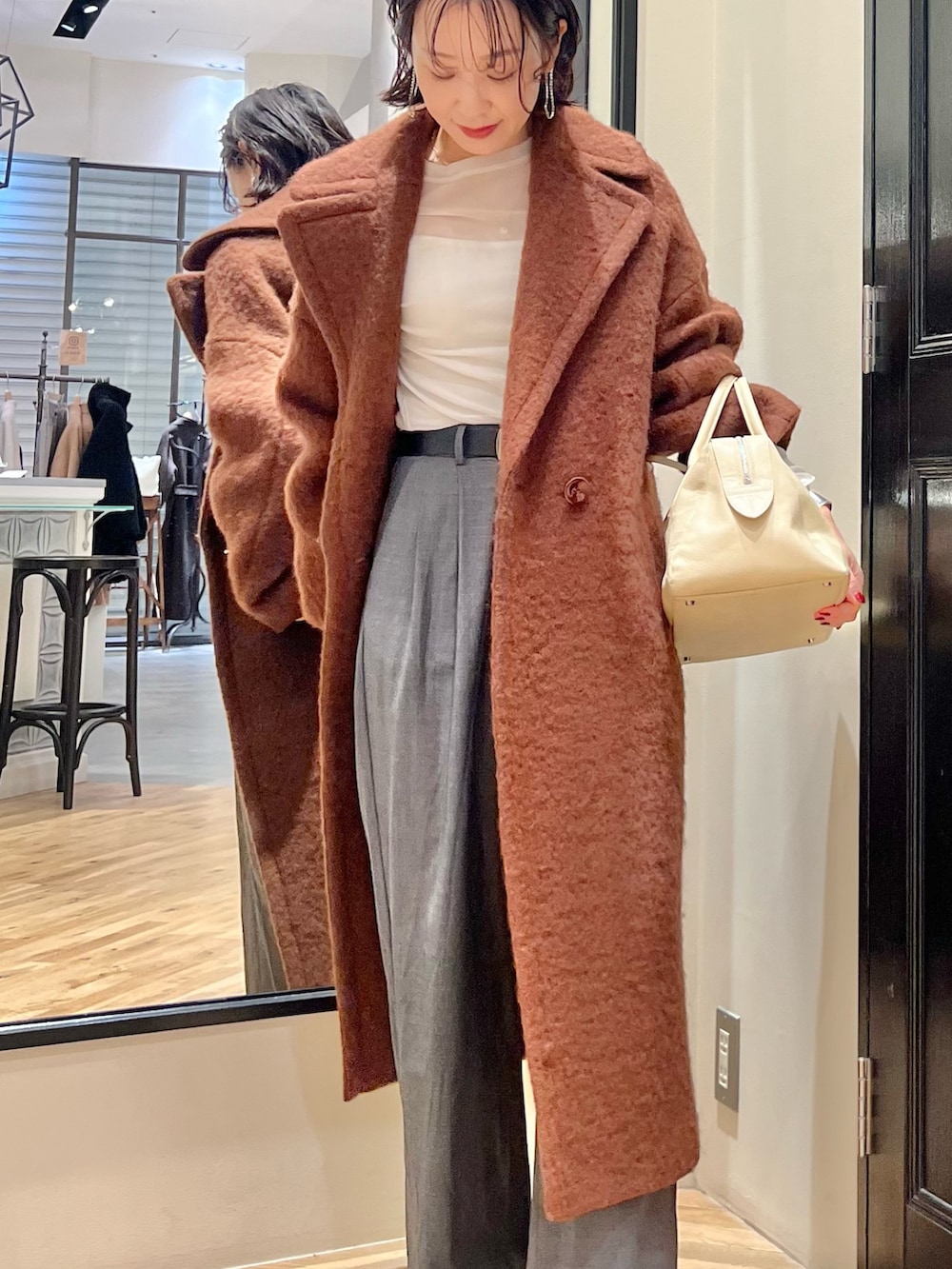 グレー系のスラックス、ホワイト系のTシャツ/カットソー、ベージュ系のトートバッグを着用したレディースの秋コーディネートの5枚目の写真