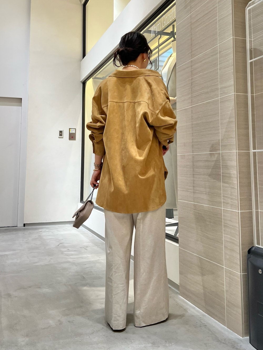 イエロー系のその他アウター、ベージュ系のその他パンツ、ベージュ系のショルダーバッグを着用したレディースの春コーディネートの2枚目の写真