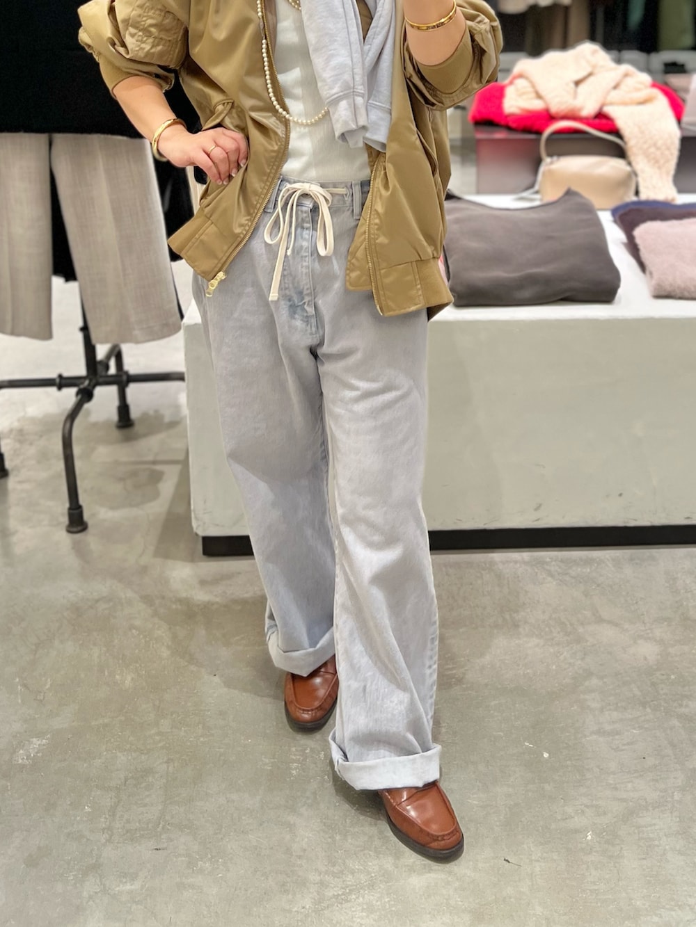 グレー系のデニムパンツ、ベージュ系のMA-1、ホワイト系のTシャツ/カットソーを着用したレディースの冬コーディネートの3枚目の写真