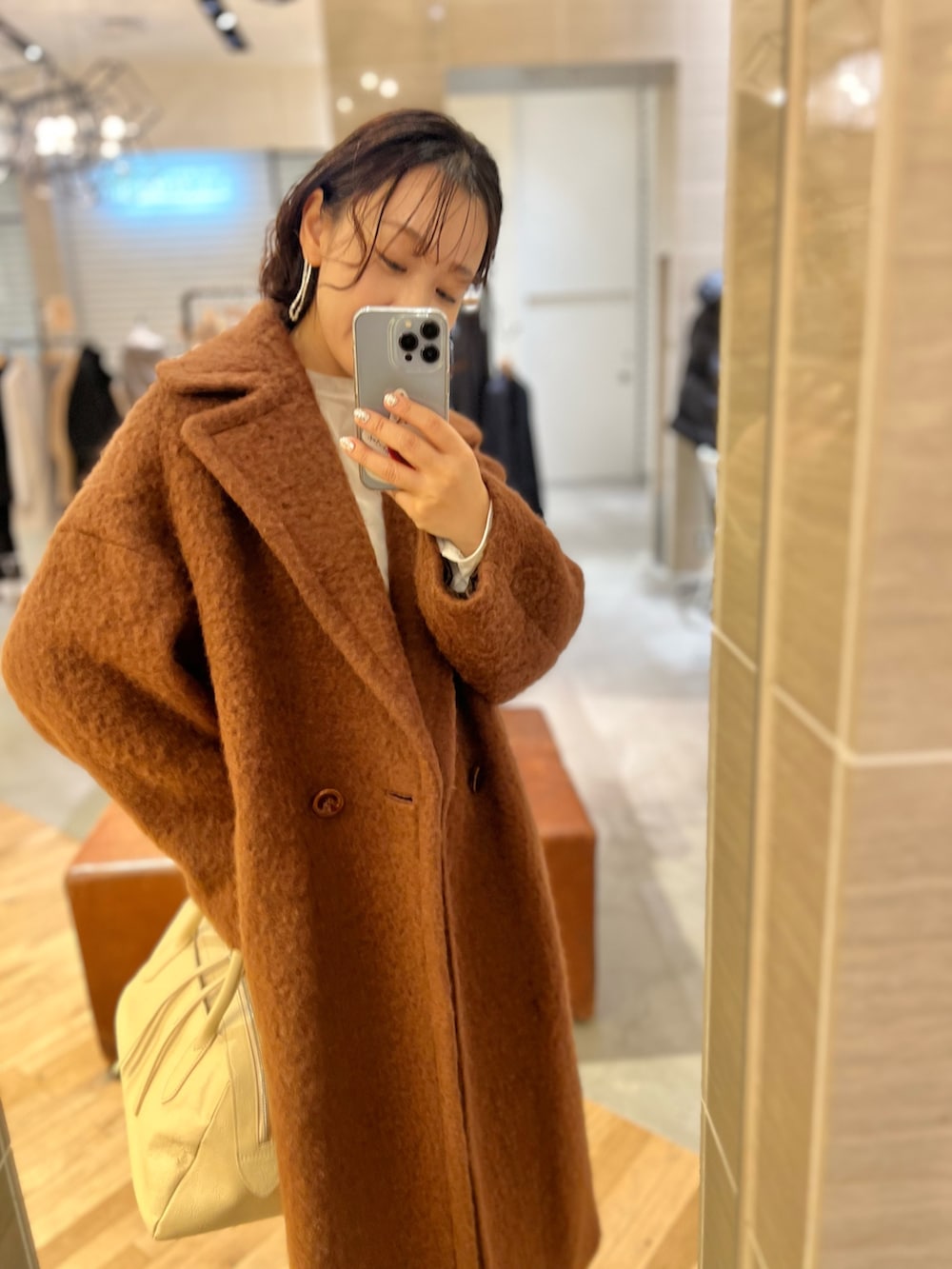 グレー系のスラックス、ホワイト系のTシャツ/カットソー、ベージュ系のトートバッグを着用したレディースの秋コーディネートの3枚目の写真