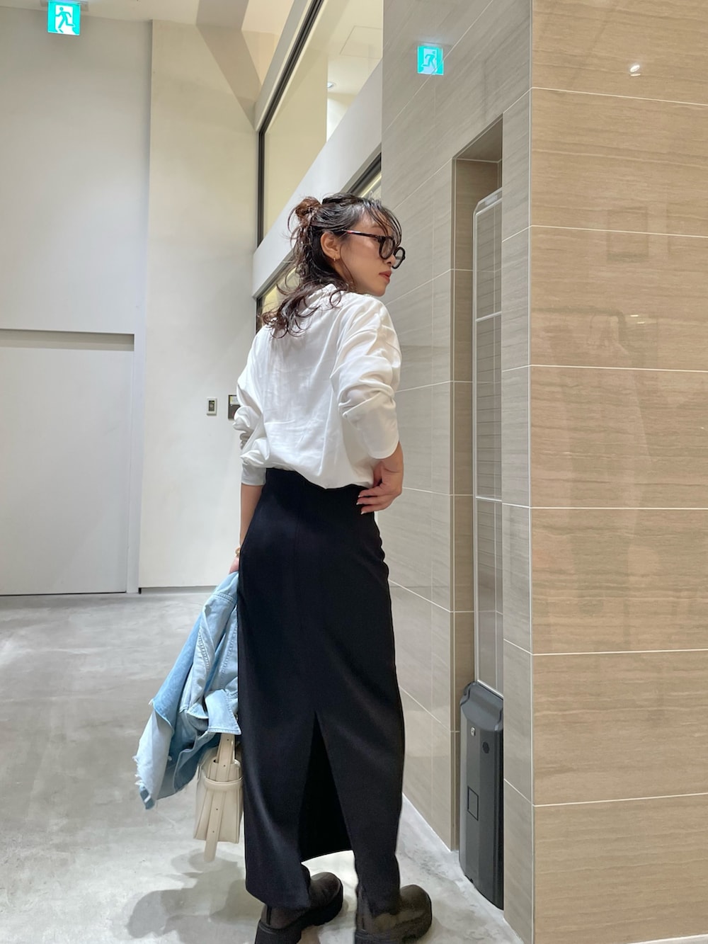 ブルー系のシャツ/ブラウス、ホワイト系のTシャツ/カットソー、ブラック系のスカートを着用したレディースの秋コーディネートの3枚目の写真