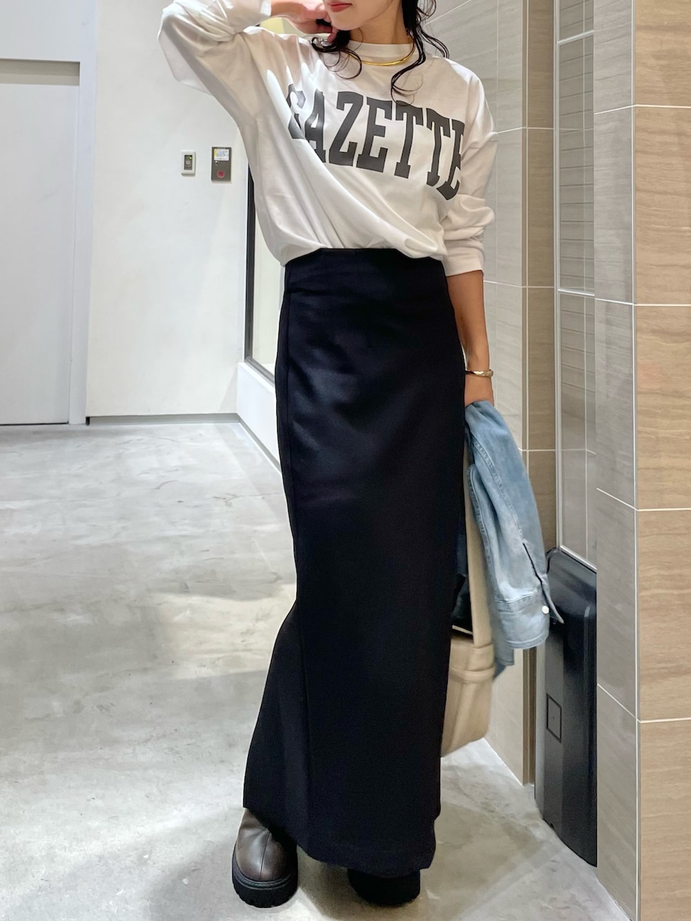 ブルー系のシャツ/ブラウス、ホワイト系のTシャツ/カットソー、ブラック系のスカートを着用したレディースの秋コーディネートの2枚目の写真