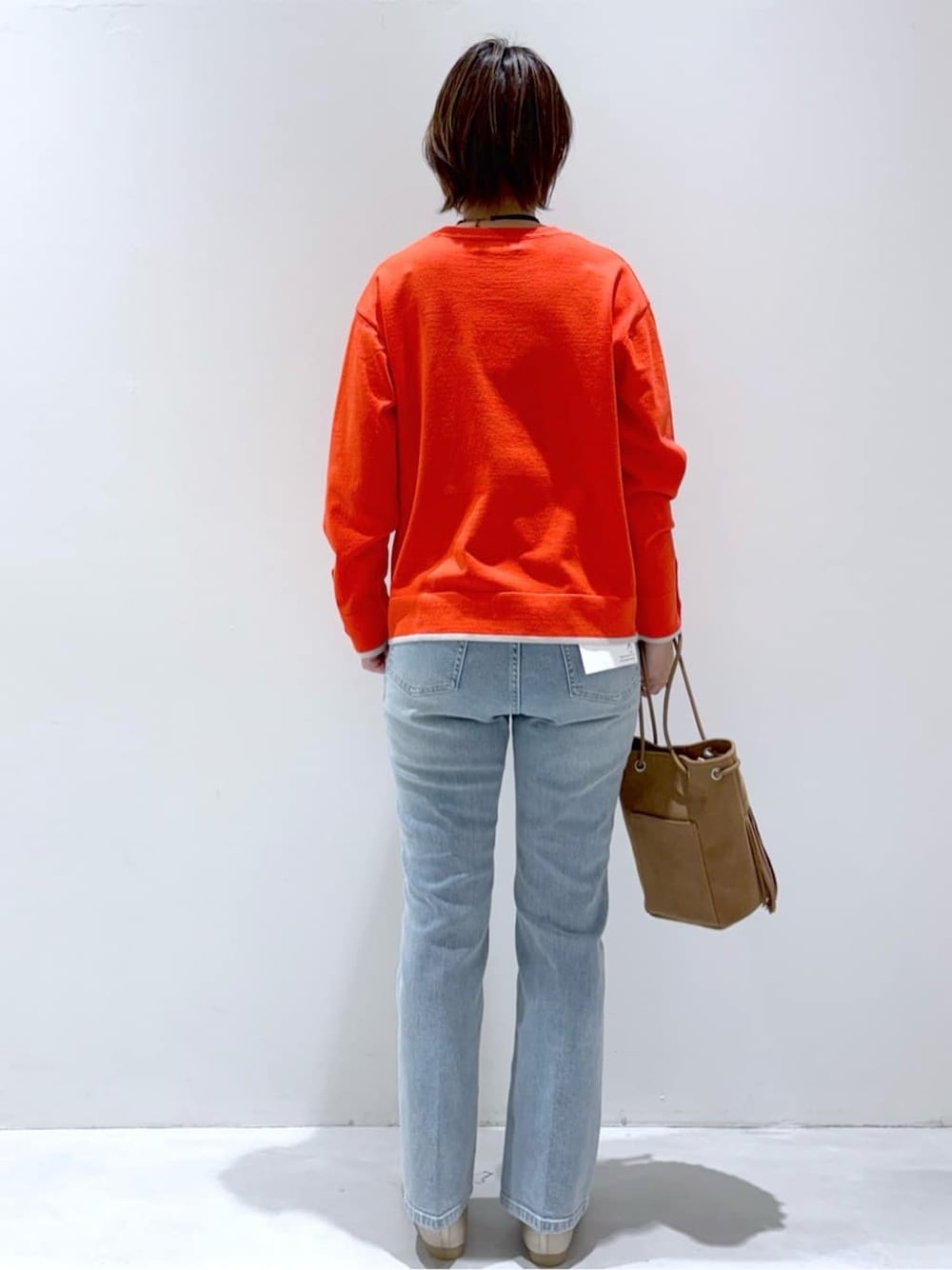 ブラック系のデニムパンツ、ブルー系のデニムパンツ、ブラウン系のトートバッグを着用したレディースの春コーディネートの3枚目の写真