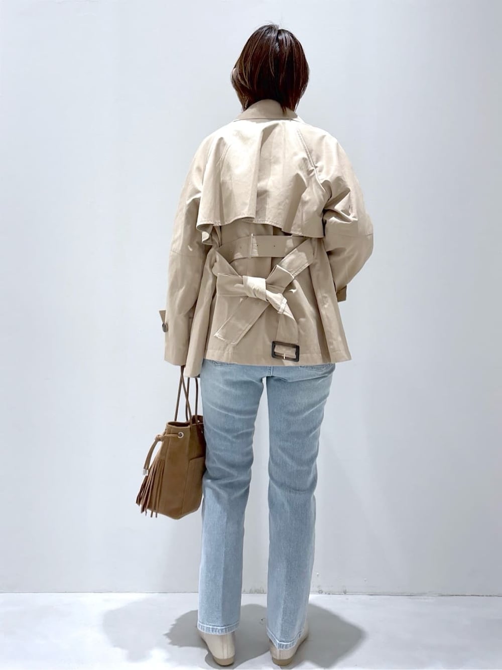 ブラック系のデニムパンツ、ブルー系のデニムパンツ、ブラウン系のトートバッグを着用したレディースの春コーディネートの3枚目の写真
