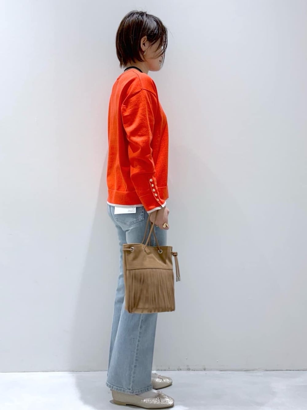 ブラック系のデニムパンツ、ブルー系のデニムパンツ、ブラウン系のトートバッグを着用したレディースの春コーディネートの4枚目の写真