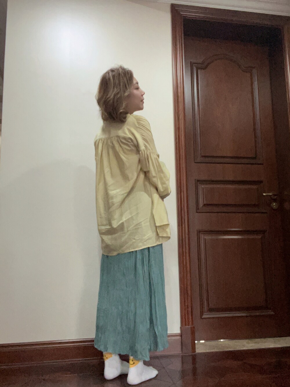 グリーン系のスカートを着用したレディースの夏コーディネートの2枚目の写真